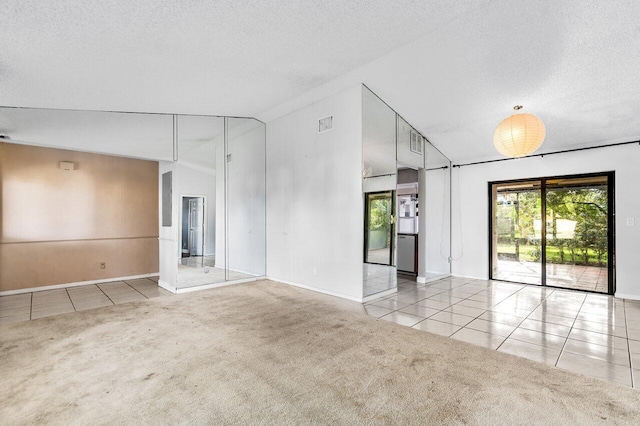 spare room featuring a textured ceiling, light carpet, and vaulted ceiling