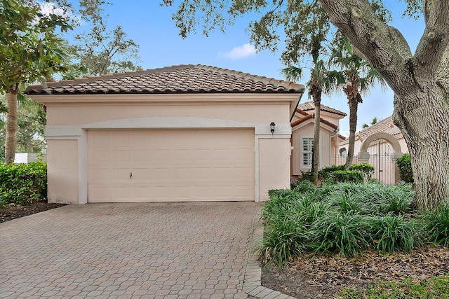 3 Via Capri, Capri, Palm Coast, FL 32137 - mediterranean / spanish-style house featuring decorative driveway, stucco siding, a tiled roof, and a garage
