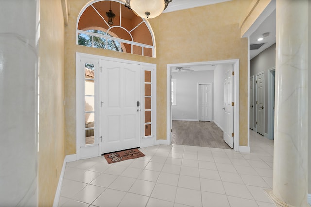 tiled entryway featuring ceiling fan and a high ceiling