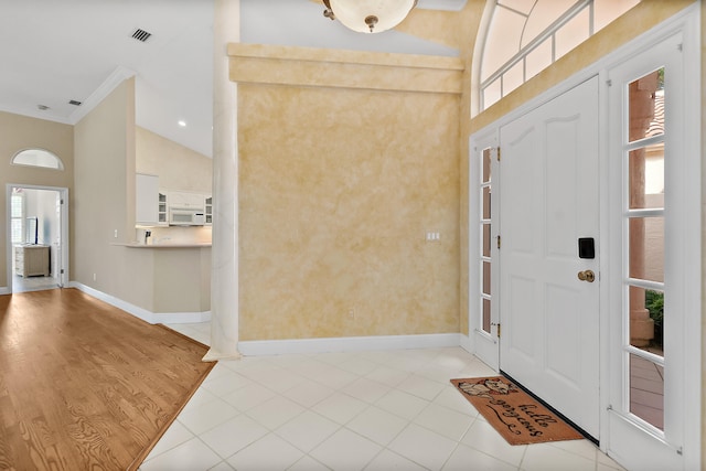 foyer entrance with light wood-type flooring and vaulted ceiling