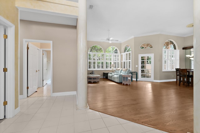 interior space featuring light hardwood / wood-style flooring, crown molding, and decorative columns