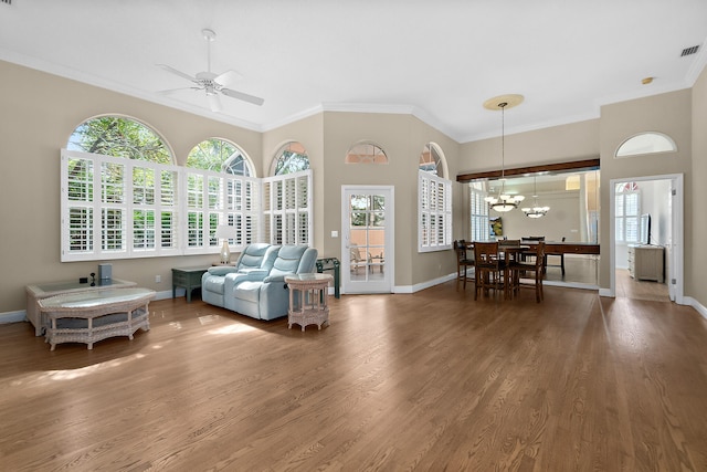 living room featuring hardwood / wood-style flooring, ceiling fan with notable chandelier, and ornamental molding