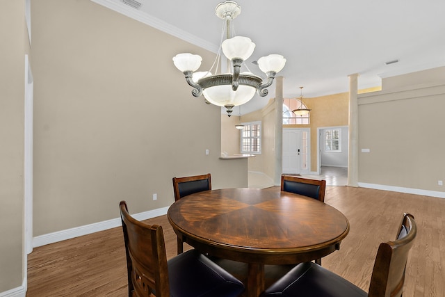 dining area featuring an inviting chandelier, hardwood / wood-style flooring, and ornamental molding