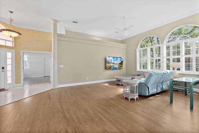 living room featuring light hardwood / wood-style floors, crown molding, and a wealth of natural light