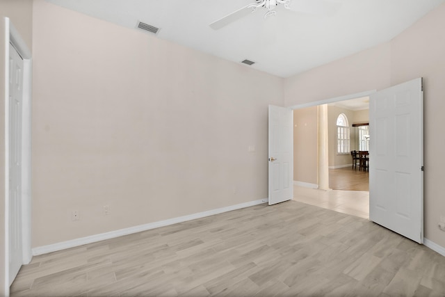 spare room with light wood-type flooring and ceiling fan