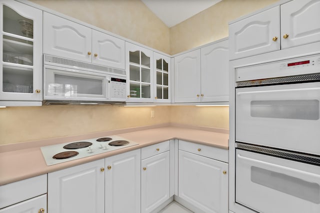 kitchen with white cabinetry and white appliances