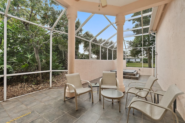 unfurnished sunroom featuring ceiling fan and plenty of natural light