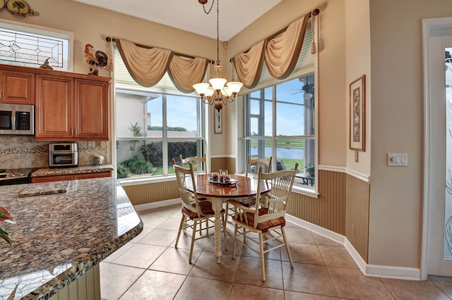 dining room featuring light tile patterned floors, an inviting chandelier, and a wealth of natural light