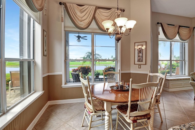 tiled dining area with ceiling fan with notable chandelier