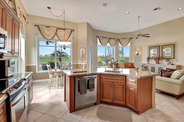 kitchen featuring plenty of natural light, light stone countertops, sink, and appliances with stainless steel finishes