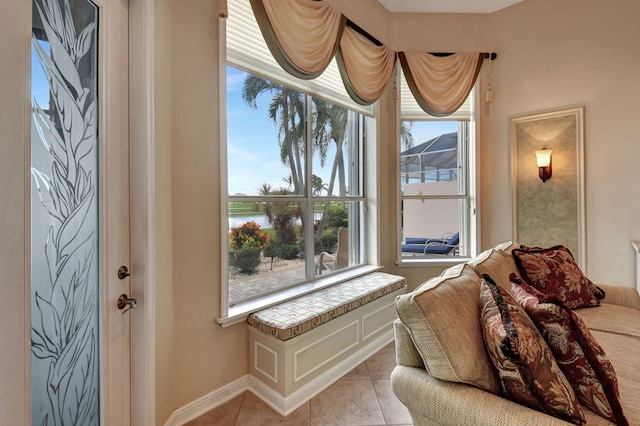 sitting room with a water view and light tile patterned flooring