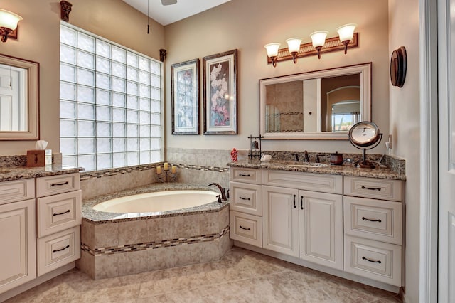 bathroom featuring tiled tub, tile patterned flooring, and vanity