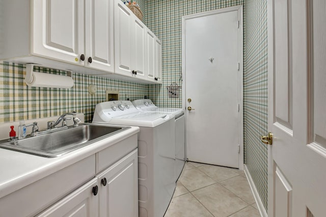 clothes washing area with cabinets, independent washer and dryer, sink, and light tile patterned floors