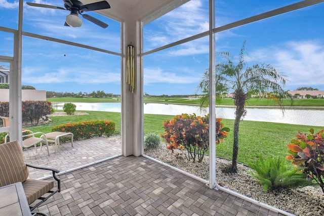 unfurnished sunroom with ceiling fan and a water view