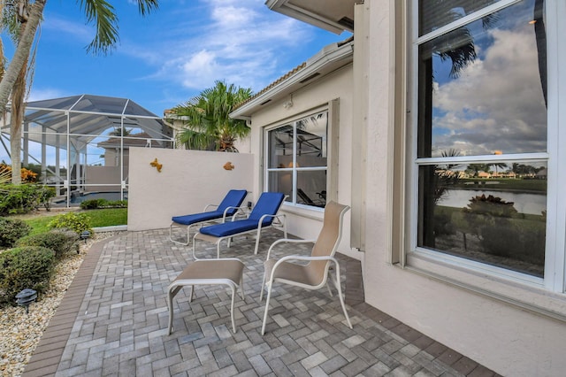 view of patio featuring glass enclosure