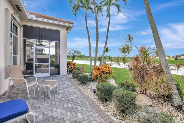 view of patio / terrace featuring a sunroom and a water view