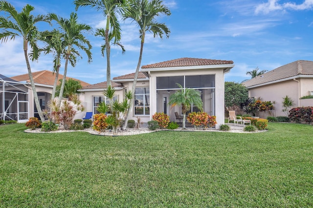 back of property featuring a lawn and a sunroom