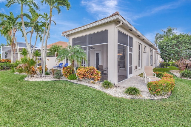 view of home's exterior featuring a lawn and a sunroom