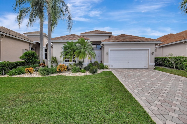 mediterranean / spanish-style home featuring a front lawn and a garage