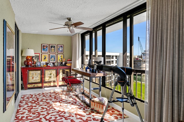 interior space with ceiling fan and a textured ceiling