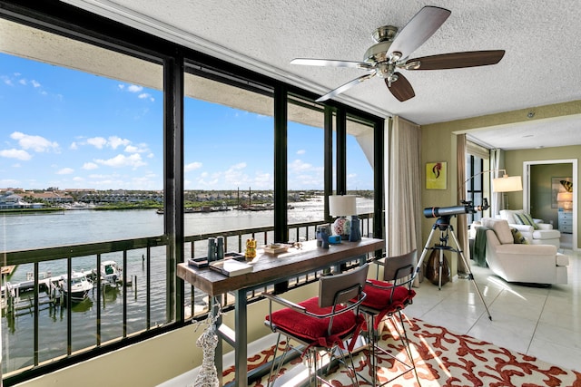 sunroom featuring a water view and ceiling fan