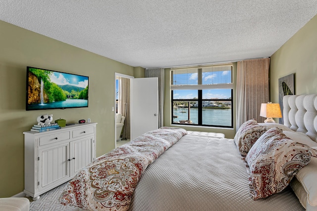 bedroom with a water view and a textured ceiling