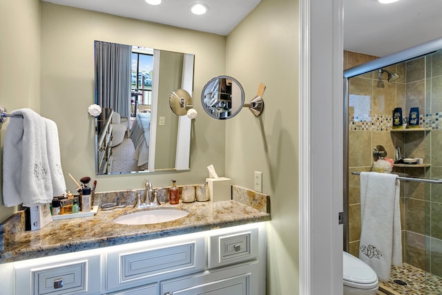 bathroom featuring walk in shower, vanity, and toilet