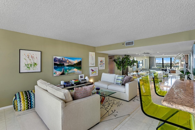 tiled living room featuring a textured ceiling