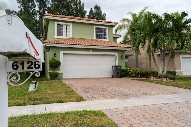 mediterranean / spanish-style home featuring a garage and a front lawn