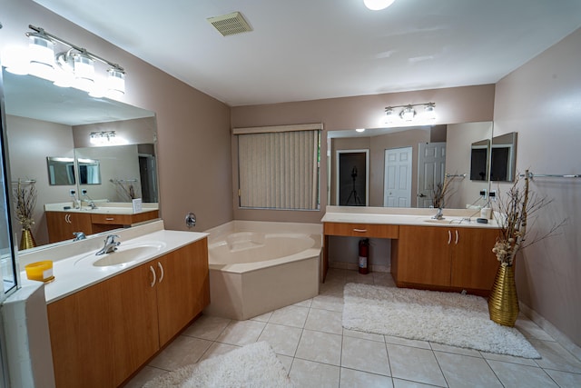 bathroom with tile patterned floors, vanity, and a tub