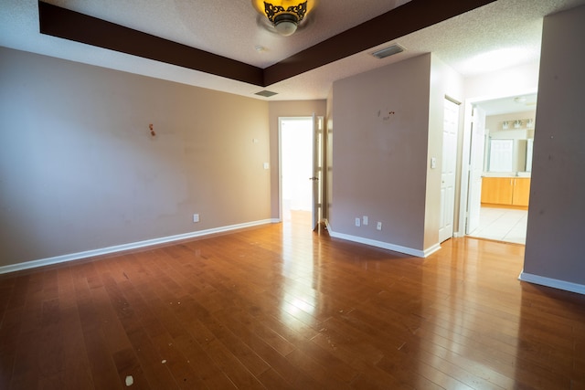 unfurnished room featuring a textured ceiling and hardwood / wood-style flooring