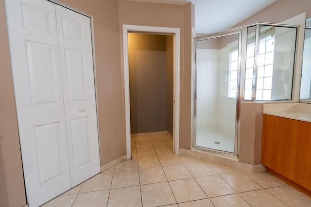 bathroom featuring tile patterned floors, a shower with door, and vanity