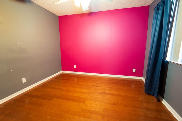 unfurnished room featuring hardwood / wood-style flooring, ceiling fan, and a textured ceiling