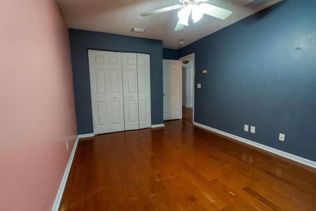 unfurnished bedroom featuring a closet, a textured ceiling, hardwood / wood-style flooring, and ceiling fan