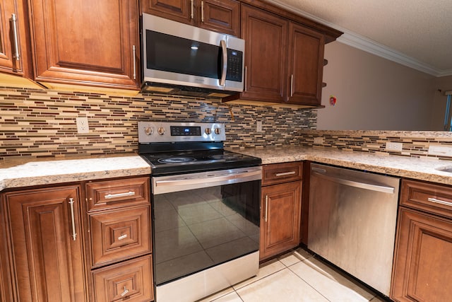 kitchen with appliances with stainless steel finishes, backsplash, light stone counters, ornamental molding, and light tile patterned floors