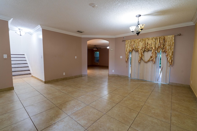 spare room with ceiling fan with notable chandelier, ornamental molding, a textured ceiling, and light tile patterned floors