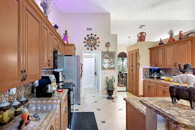 kitchen with stainless steel electric range, light stone countertops, a textured ceiling, light tile patterned floors, and tasteful backsplash