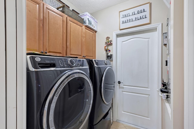 laundry area featuring cabinets, separate washer and dryer, a textured ceiling, and light tile patterned floors