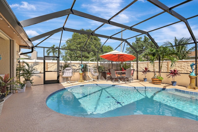 view of pool with a patio and glass enclosure