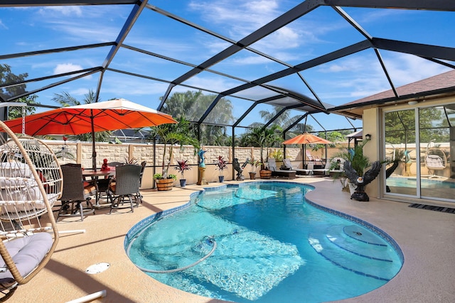 view of swimming pool with glass enclosure and a patio