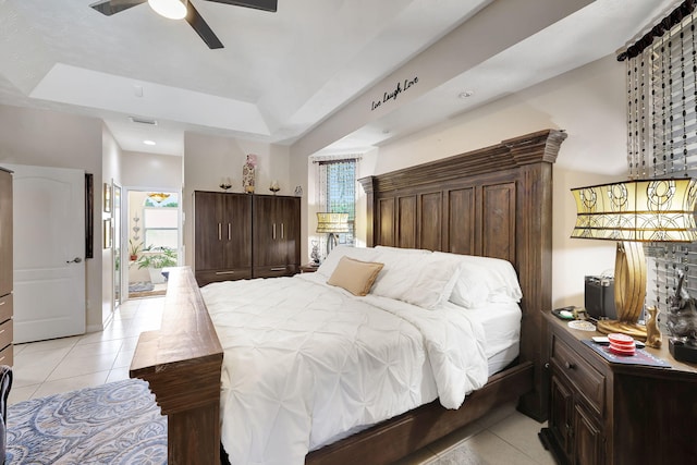 tiled bedroom featuring a raised ceiling and ceiling fan