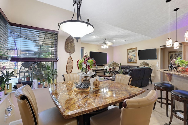 tiled dining space featuring ceiling fan and a textured ceiling