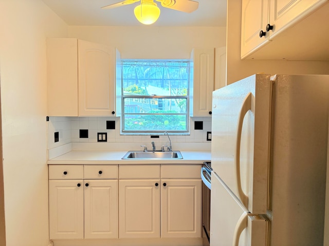 kitchen with white cabinets, white refrigerator, sink, ceiling fan, and tasteful backsplash