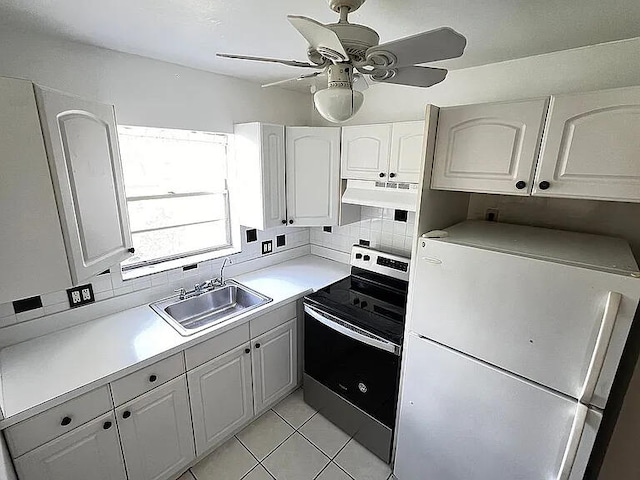 kitchen featuring white cabinets, backsplash, white fridge, and stainless steel electric stove