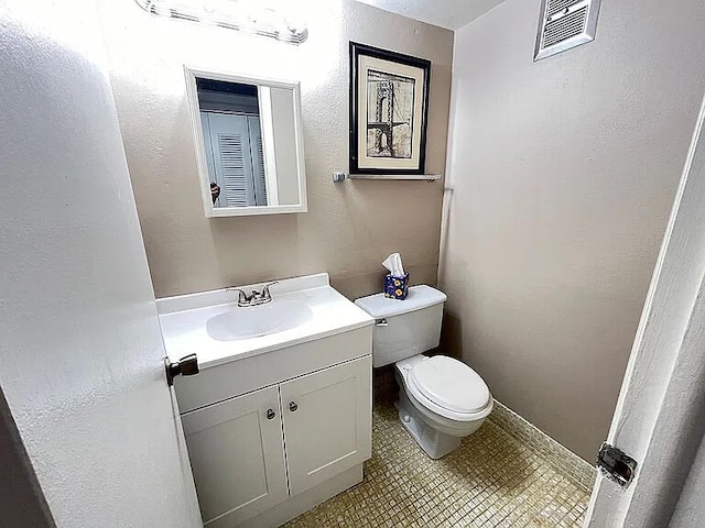 bathroom featuring tile patterned floors, vanity, and toilet