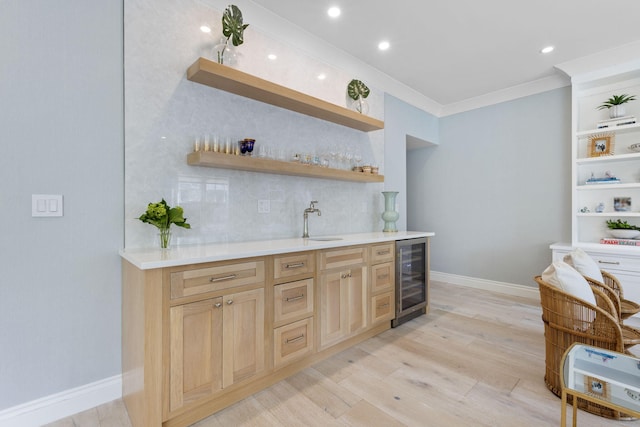 bar featuring sink, beverage cooler, tasteful backsplash, light hardwood / wood-style flooring, and ornamental molding