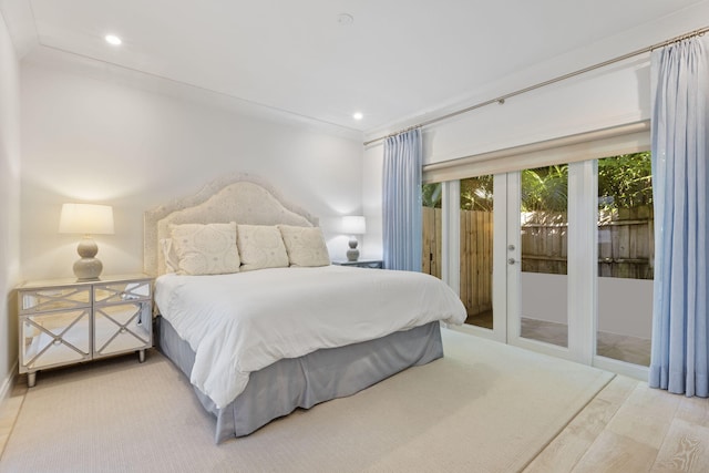 bedroom with wood-type flooring, ornamental molding, access to exterior, and french doors