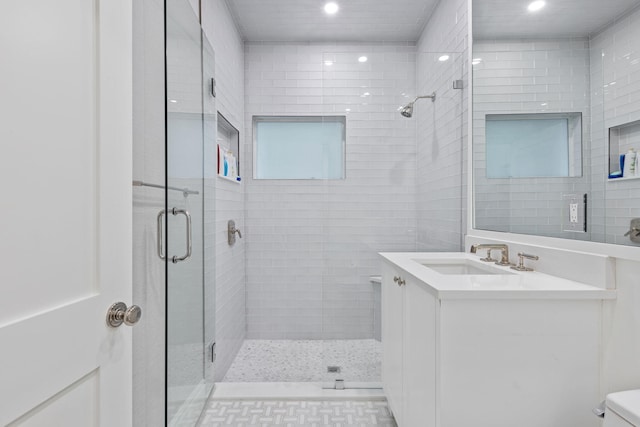 bathroom featuring vanity, an enclosed shower, and toilet