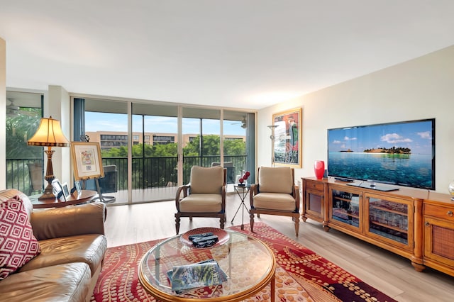 living room with plenty of natural light, expansive windows, and light wood-type flooring