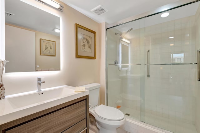 bathroom with vanity, toilet, and a shower with shower door